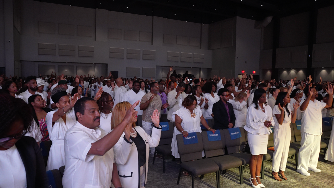 A full room worshiping with hands raised at Eagles Nest Church